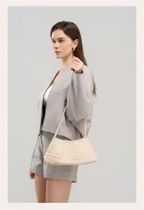 Detailed view of the beige woven leather underarm shoulder bag worn by model, elegant design.