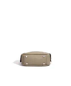 Vue de fond détaillée d'un sac à main en cuir véritable avec des clous métalliques de qualité.