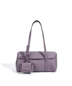 Leder Umhängetasche in Lila mit kleinem Anhänger und elegantem geknoteten Schulterriemen.