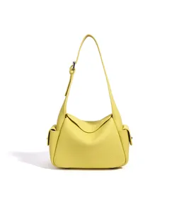 Vue détaillée du sac à bandoulière en cuir jaune, texture de vache, poches latérales.