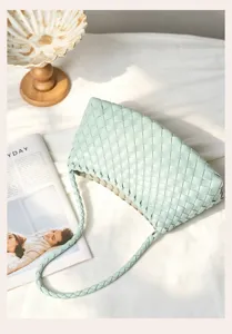Detailed close-up view of light green woven leather shoulder bag with classic style.