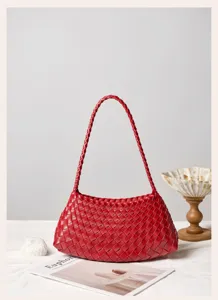 Detailed view of the elegant red woven leather shoulder bag, highlighting craftsmanship.