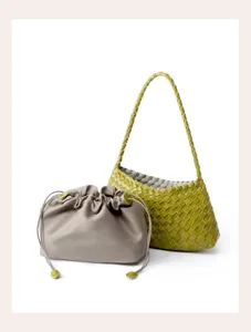 Green woven leather shoulder bag combined with grey drawstring pouch for commute.