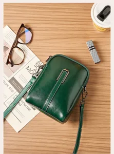Dark green leather crossbody phone bag for women, stylish mini shoulder bag with metal lock.