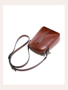 Stylish brown leather mini crossbody phone bag for women featuring an adjustable long strap.