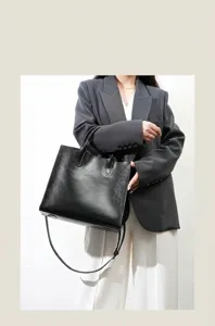 Black leather tote bag for women, stylish commuting shoulder handbag with large capacity.