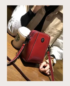 Detailed view of genuine leather small crossbody mobile phone bag in casual lifestyle scene.