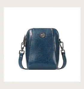 Detail shot of dark blue oil-wax leather phone bag featuring a metal flower accent.