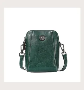 Detail view of dark green oil-wax leather crossbody phone bag showing texture and hardware