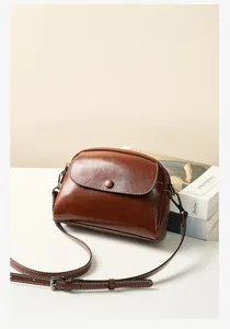 Vintage brown leather crossbody bag for women, stylish minimalist shell shoulder bag with strap.