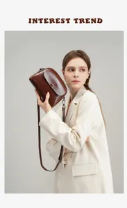 Close-up detail of retro brown leather crossbody bag, showcasing fine texture and classic style.