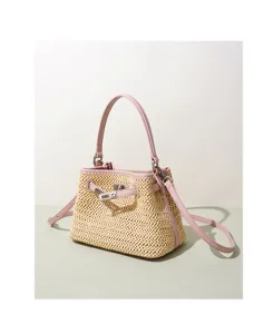 Charming straw woven handbag with pink leather trim and metal lock detail, perfect for spring.