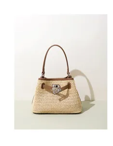 Straw woven handbag detail featuring brown leather trim and metal lock closure for summer.