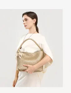 Gold woven shoulder bag detail shot showcasing artisanal intrecciato leather craftsmanship.