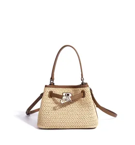 Straw woven handbag detail view with brown leather trim and unique metal lock closure.