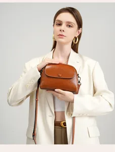 Detail shot of the vintage brown leather cross-body bag showing fine texture and hardware.