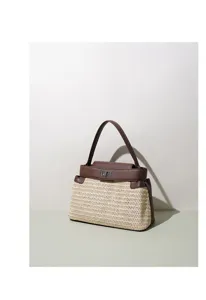 Détail de sac à main en paille tressée avec bordure en cuir marron et fermeture tourniquet.