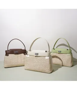 Vue detaillee de sacs a bandouliere en paille tresses avec garniture en cuir et fermoir.