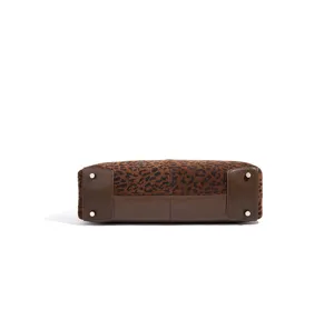 Detailansicht des Taschenbodens aus Leoparden-Wildleder und braunem Leder mit Füßchen.