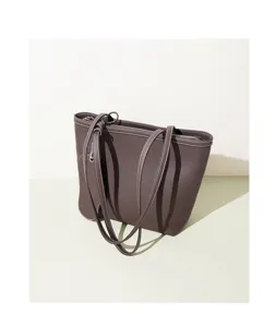 Detalle del bolso tote de piel con textura suave, costuras cuidadas y asas dobles resistentes