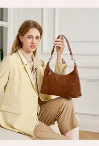 Close-up detail of the brown suede shoulder bag, showing soft texture and hardware.