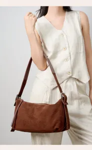 Borsa a tracolla in camoscio indossata dalla modella, con cinturino largo e alta qualità.