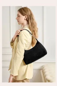 Model wearing black suede shoulder hobo bag in lifestyle detail scene for women commute.