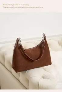 Detailed view of brown suede women underarm shoulder bag, stylish commuter handbag with hardware.
