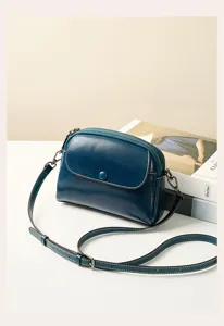 Detail view of a retro genuine leather women crossbody bag in dark blue with fine strap.