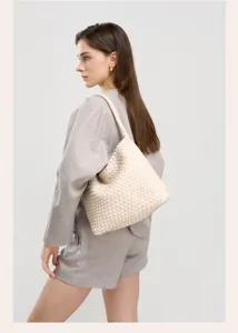 Detailed view of the beige woven leather shoulder bag showcasing craft texture and elegance.