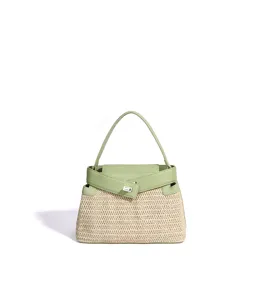 Vue détaillée du sac à main en paille de plage d'été avec garniture en cuir vert et fermoir.