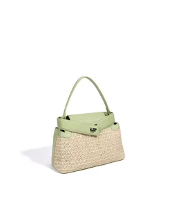 Détail du sac à main en paille tissée et cuir vert montrant la structure et le fermoir métal.