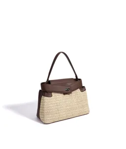 Gros plan sur le sac a main en paille avec empiècements en cuir marron et fermoir métallique.