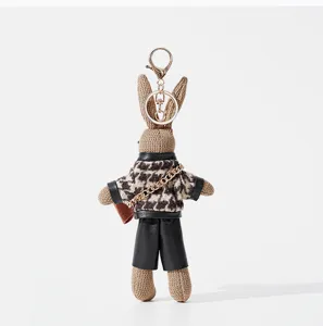 Gros plan détaillé du joli porte-clés en peluche lapin pied-de-poule et fermoir dorée.