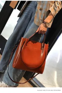 Bolso de mano para mujer en cuero de vaca, elegante bolso marron con bolsillo frontal redondo.