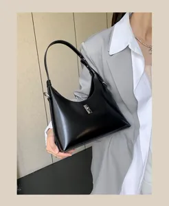 Detailed view of the sleek black leather shoulder bag with chic metal lock and elegant strap.