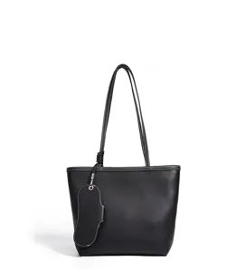 Primer plano del elegante bolso tote de cuero negro, textura prémium y costuras cuidadas.