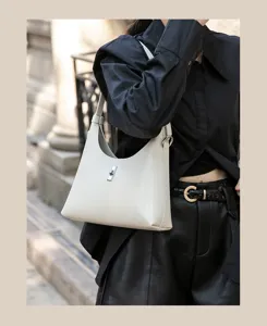 Minimalist white leather shoulder bag detail, stylish hobo design with metal lock closure.