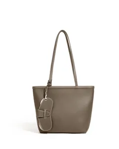Primer plano detalle del asa del bolso tote de cuero gris y su superficie texturizada de grano.