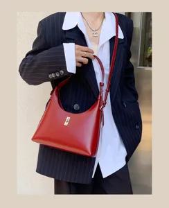 Red leather shoulder bag detail, stylish underarm hobo bag with metal lock hardware.