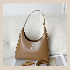 Chic brown leather shoulder bag for women, stylish hobo design with metal lock closure.