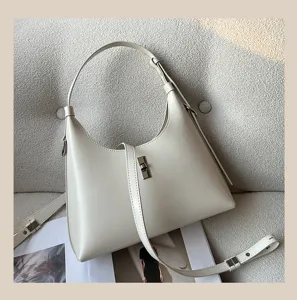 Detailed view of the chic cream leather shoulder bag with metallic clasp and adjustable strap.