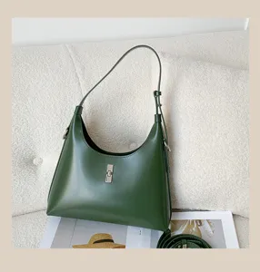 Stylish green leather shoulder bag for women, elegant hobo handbag with metal lock design.