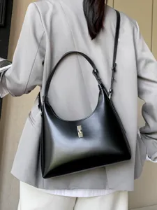 Stylish black leather shoulder bag for women, chic crescent hobo design with metal lock.