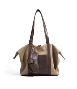 Vue détaillée du sac cabas en toile décontracté avec anses contrastées et pendentif.