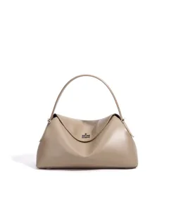 Détail sac à main taupe, design minimaliste de sac oreiller avec fermeture à tourniquet.