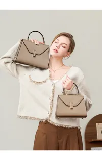 Detail shot of stylish genuine leather top handle bag with metal clasp for modern women.