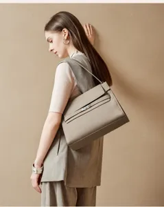 Detailansicht der eleganten strukturierten taupefarbenen Ledertasche am Model.