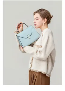 Elegant light blue leather top-handle handbag detail, premium commuter style with metal clasp.