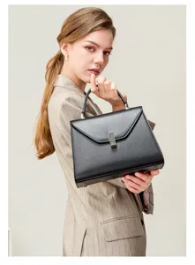Detailed view of a classic black leather handbag featuring elegant metal hardware closure.